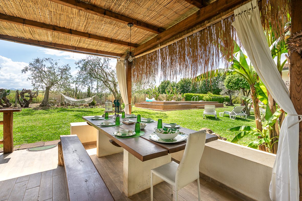 Pergola in legno con il tavolo apparecchiato all'aperto